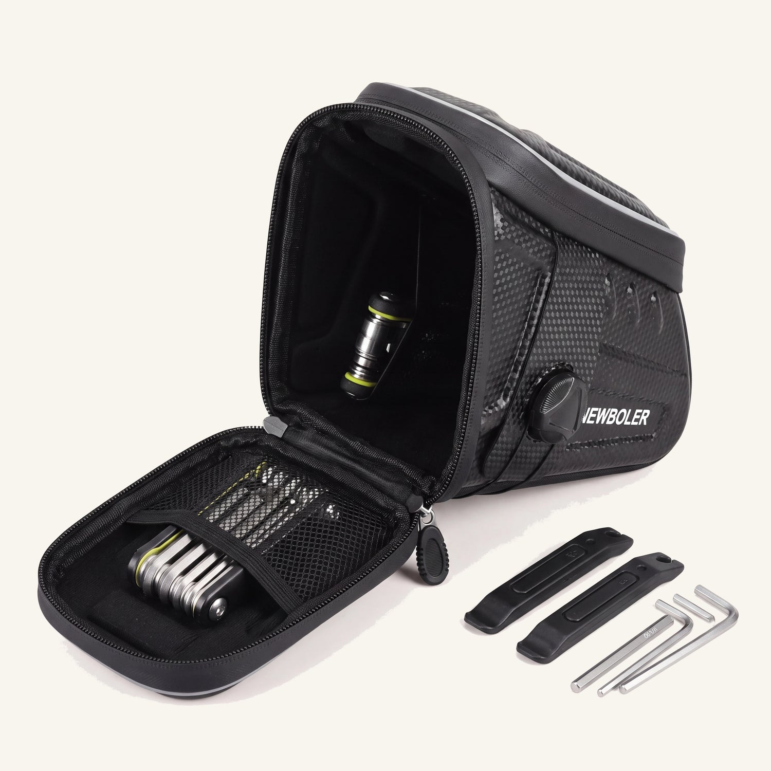 Sacoche de selle vélo ouverte montrant la poche filet et un kit de réparation : multi-outil, démonte-pneus, clés Allen