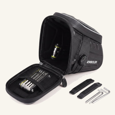 Sacoche de selle vélo ouverte montrant la poche filet et un kit de réparation : multi-outil, démonte-pneus, clés Allen
